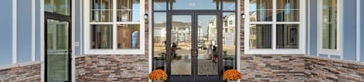 the view of the front porch of a brick building with glass doors