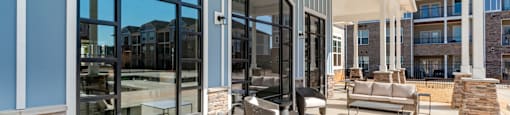 a covered patio with furniture and glass doors