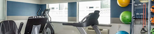 a gym with various exercise equipment at the enclave at university heights