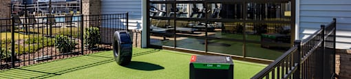 A house with a green artificial grass area in front.