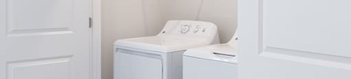 A white washing machine and dryer in a small laundry room.