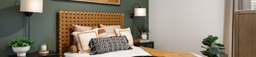 A bedroom with a bed, nightstands, and a painting on the wall.