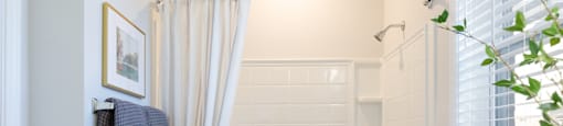 A white bathroom with a white tub and a white toilet.