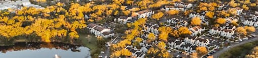 an aerial view of a city with trees and a lake