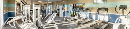 a gym with a lot of machines and weights