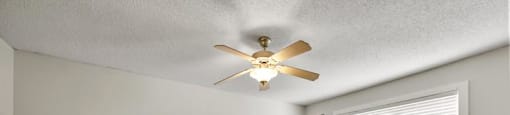 an empty bedroom with a ceiling fan and a window