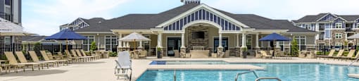 A large swimming pool with a slide and sun loungers.