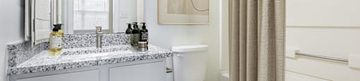 a bathroom with a toilet and a shower and a sink