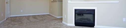 an empty living room with a fireplace and a chandelier