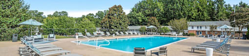 a swimming pool with chairs and umbrellas at the resort