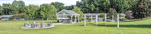 a park with picnic tables and a pavilion on the grass