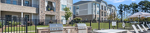 A sunny day at a residential complex with a pool table and chairs.