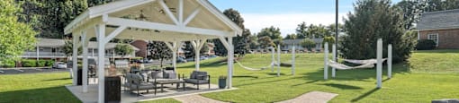 a picnic area with a pavilion and benches in a park