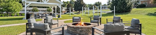 a patio with chairs and a fire pit