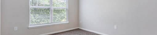 A room with a carpeted floor and a ceiling fan.