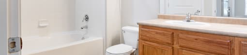A bathroom with a toilet, sink, and bathtub.