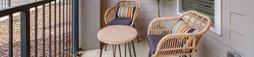 two chairs and a table on the porch of a house