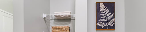 a bathroom with a toilet and a shelf with towels