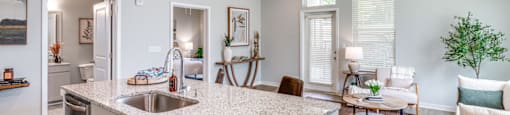 the view of a living room and a kitchen with a sink