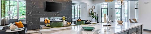 a large kitchen with an island and a living room with a tv