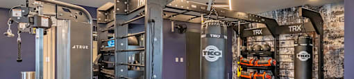 a gym with punching bags and other equipment in a home gym