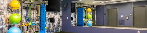 the fitness center has a gym with a blue wall and colorful balls