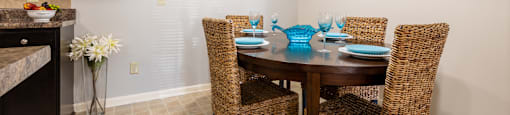 A dining room with a table set for four.