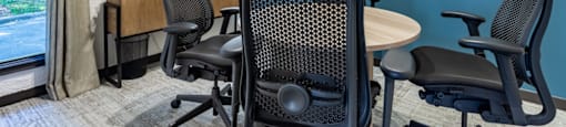 a conference room with a table and chairs and a window