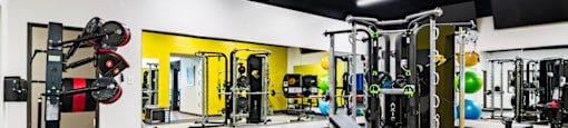 a gym with weights and cardio equipment and a wall of mirrors