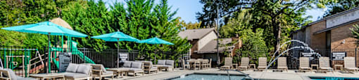 our resort style swimming pool is surrounded by lounge chairs and umbrellas