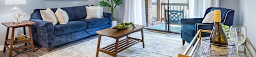 a living room with blue furniture and a sliding glass door to a balcony