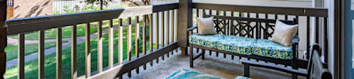 a covered porch with a bench and a window