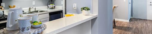 our apartments offer a kitchen with white cabinets and a counter top