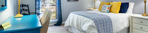 a bedroom with a bed and a desk and a window