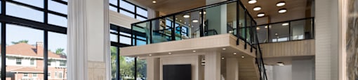 A billiard table is in the middle of a room with a balcony.