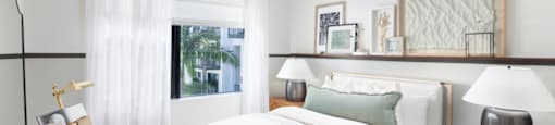 A bedroom with a large bed and a ceiling fan.