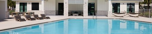 A large white house with a pool in front.