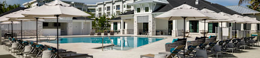 A poolside area with sun loungers and umbrellas.