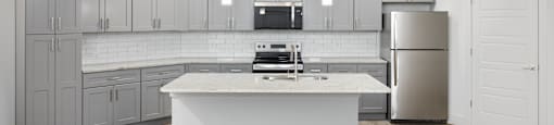 A modern kitchen with a white island in the middle.