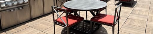 a patio with a table and chairs on a rooftop