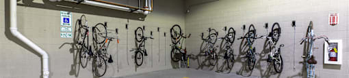 A bike parking area with bicycles hanging on the wall.