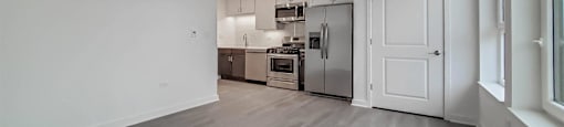 A spacious kitchen with a refrigerator, oven, and sink.