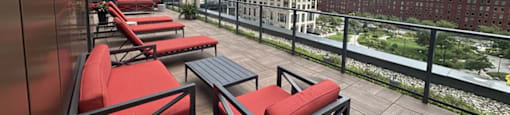 a balcony with red chairs and a view of skyscrapers