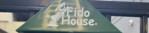 a bird house with a green bird figurine in it