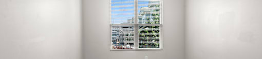State Street Flats one bedroom apartments in Nashville TN bedroom with a ceiling fan and a window overlooking a cityscape.
