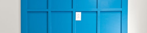 State Street Flats Apartments wall mounted electric fireplace with a blue wall behind it.