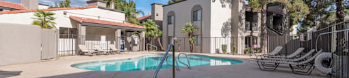sunny pool area in front of apartment complex with shaded spa