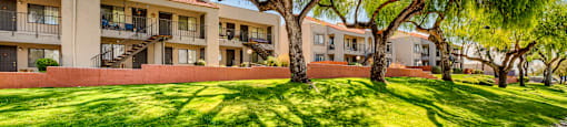 A grassy area in front of apartment buildings.