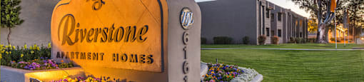 Riverstone community sign with lush landscape and flowers surrounding