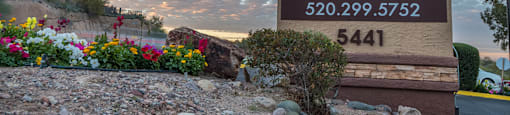 Foothills community sign with well kept entrance accompanied by colorful flowers
